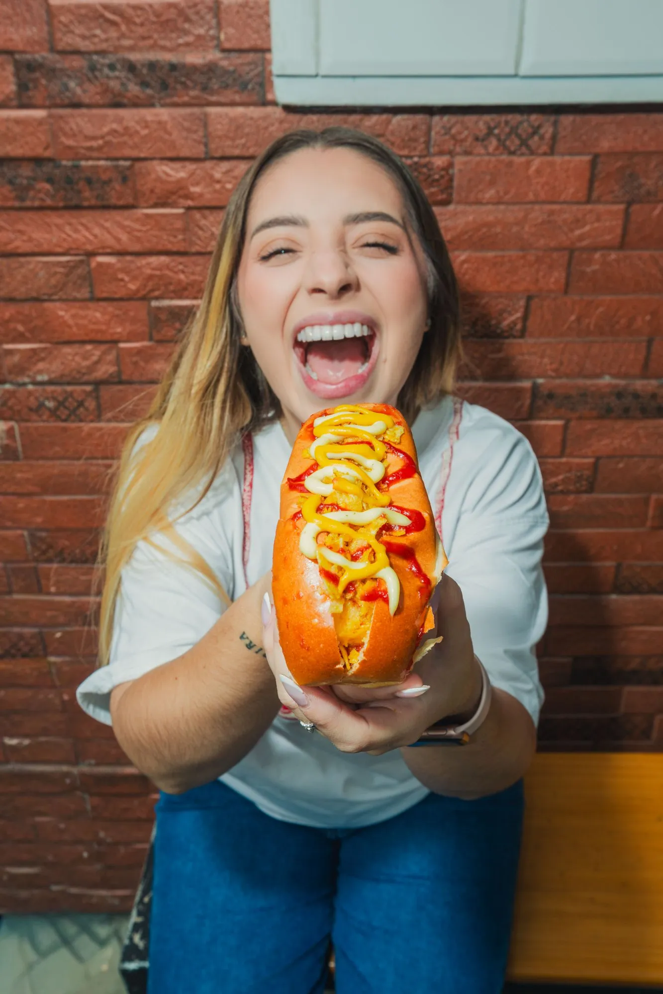 La Caliente customer holding out a hot dog